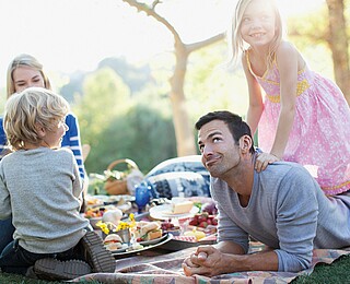 California, USA --- Family picnicking in grass --- Image by © Ocean/Corbis