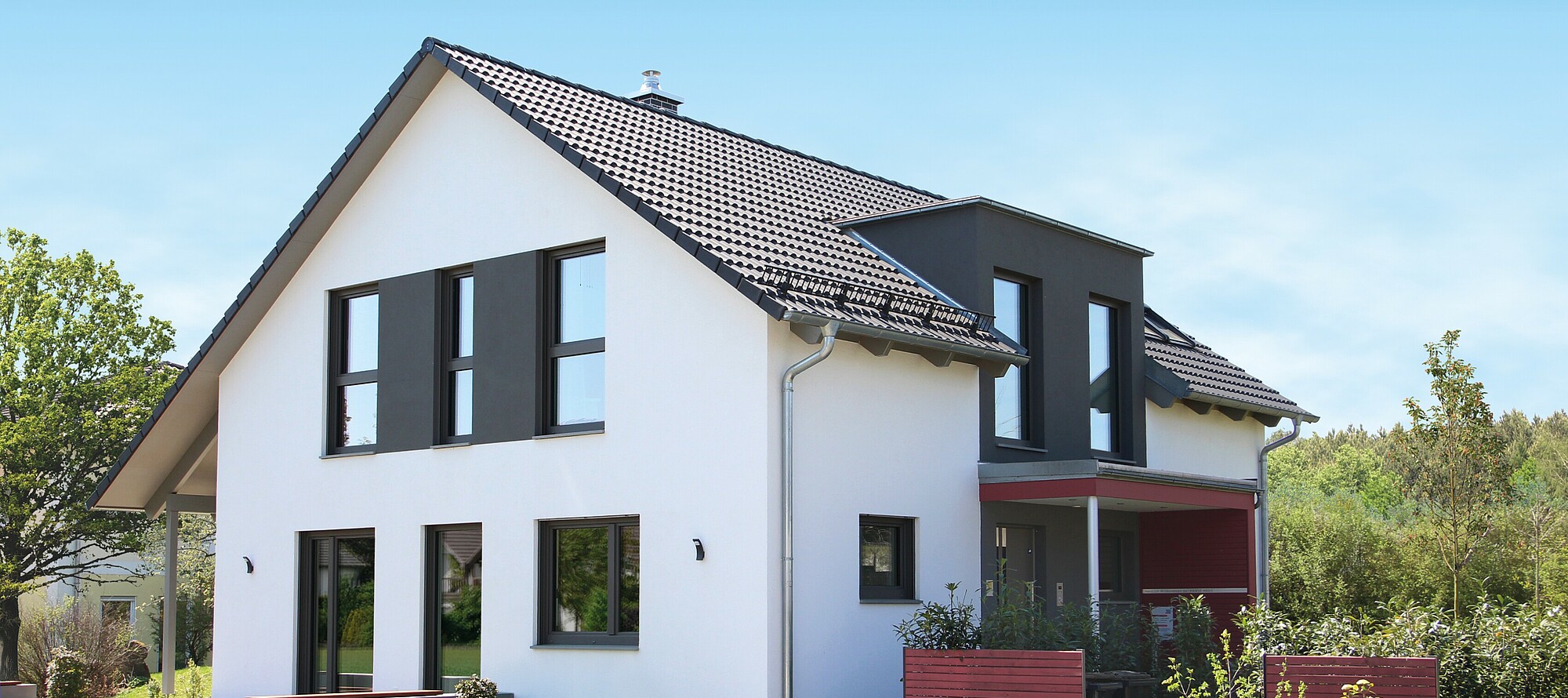 Haus mit Satteldach und schwarzer Gaube